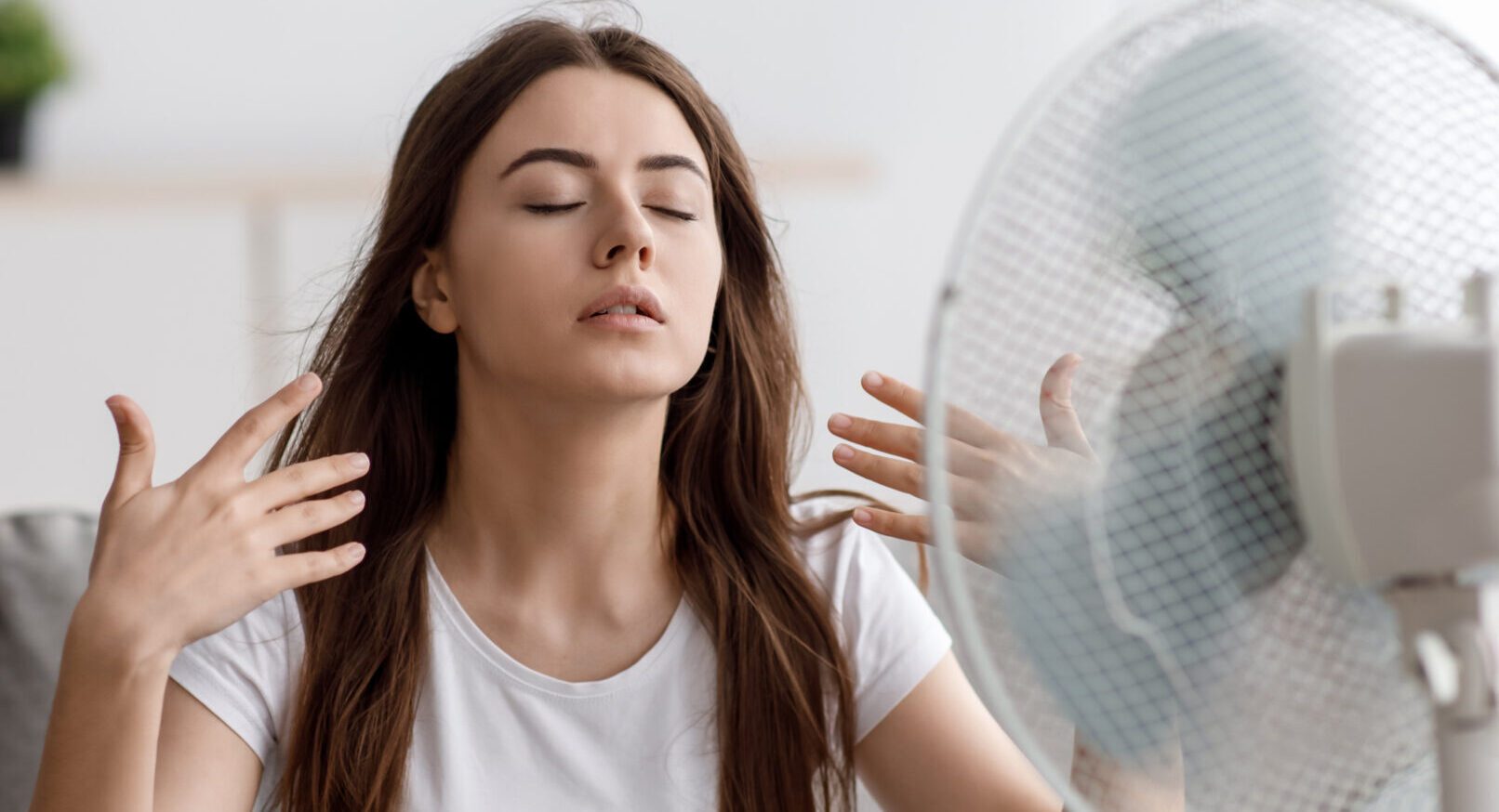 Woman in front of a fan needing HVAC repair services in Montgomery County PA