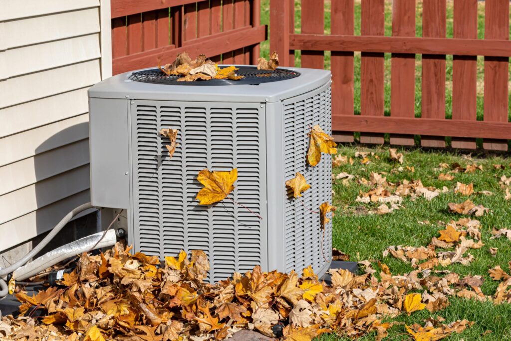 Dirty air conditioning unit cover in leaves during autumn. Home